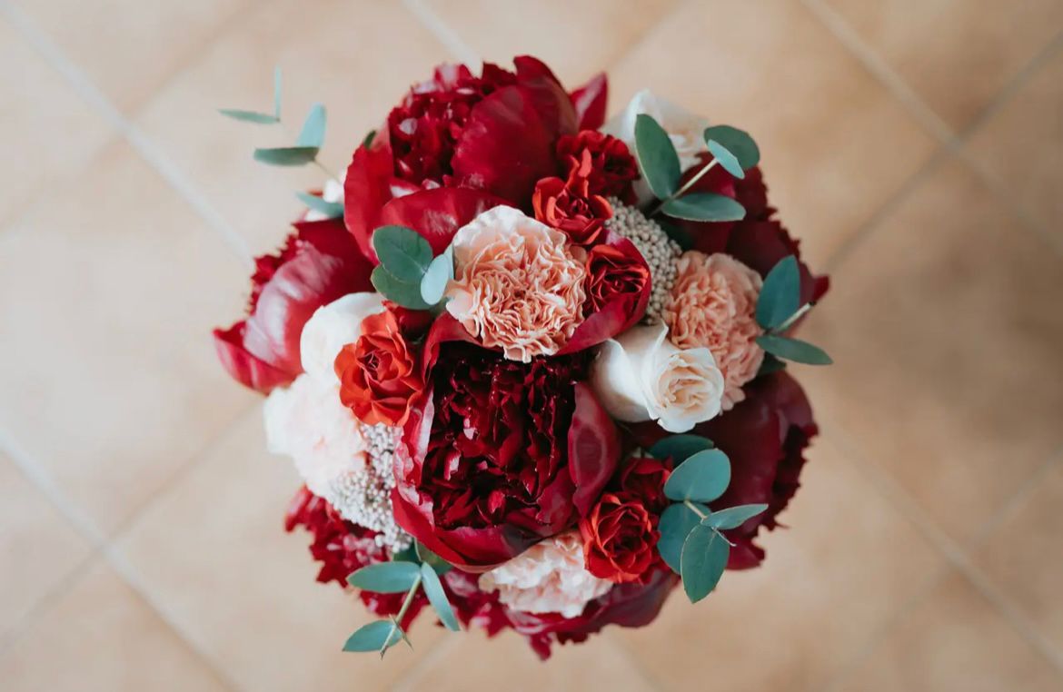 Bouquet LIPPOLIS con peonie rosse borgogna e garofani cipria — stile drammatico passionale